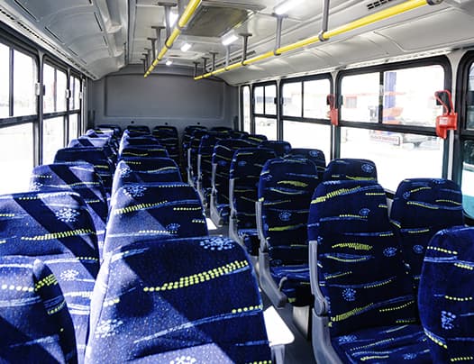 Interior de una unidad de Punto Transportes con asientos reclinables en tela azul