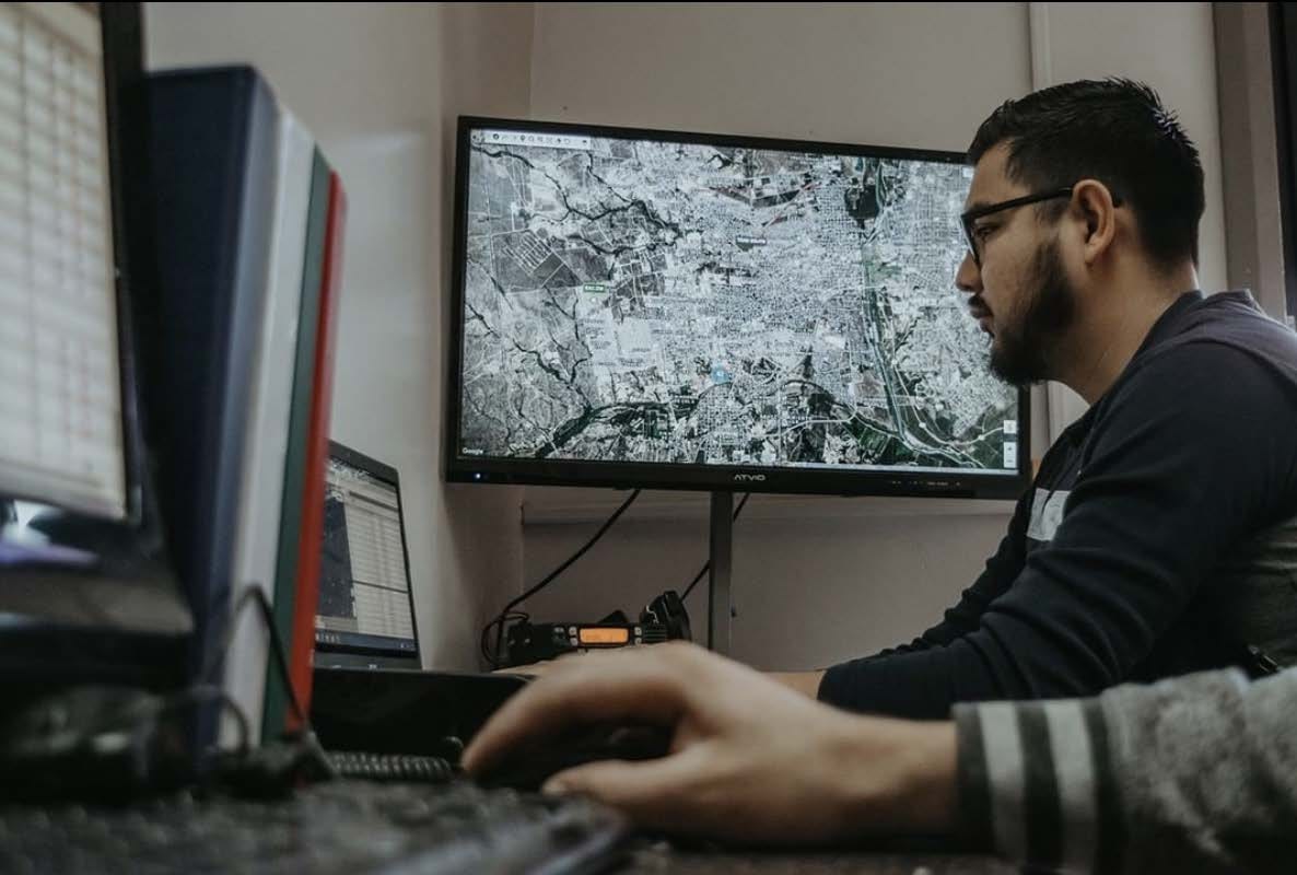 Monitorista de Punto Transportes siguiendo las rutas en el mapa del centro de monitoreo